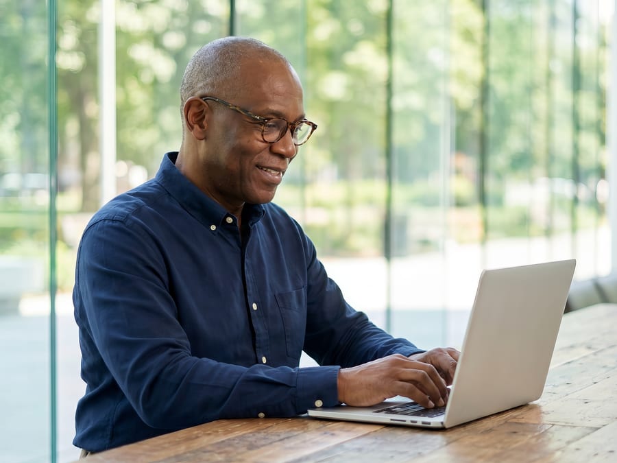 An executive working on his laptop at a bright office desk